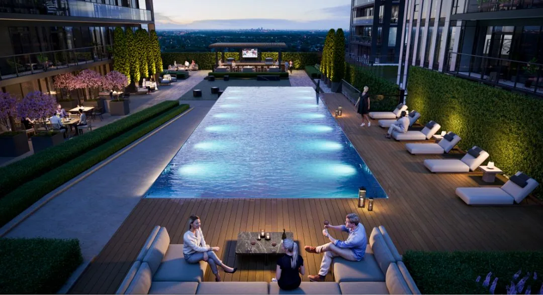 Rendering of the outdoor pool terrace at night with loungers, cabanas and the city skyline beyond